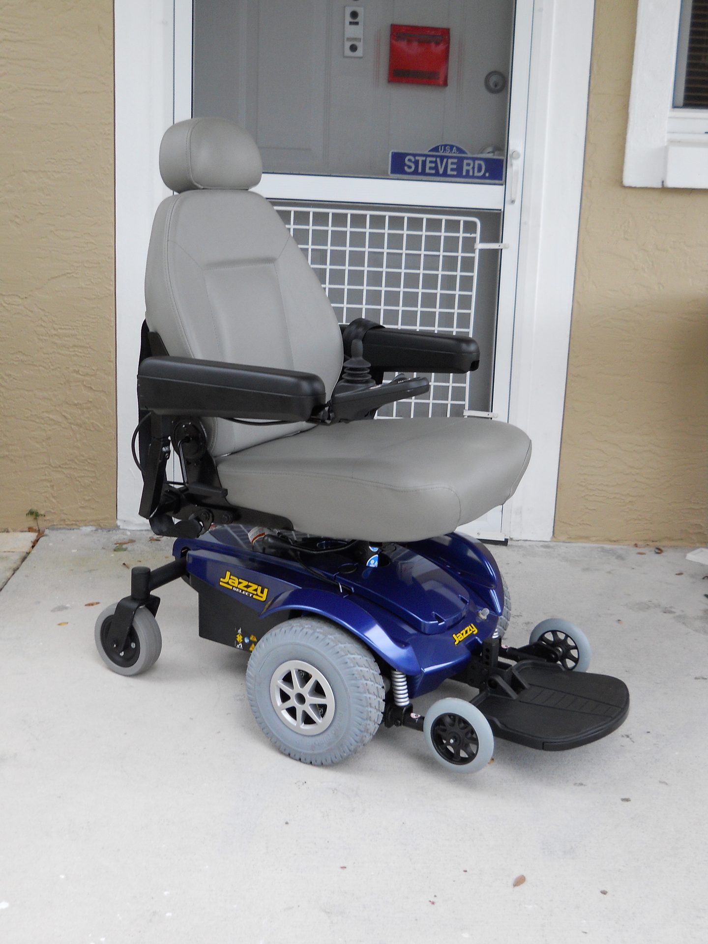 Figure 10.2 — Pride Jazzy Select Mid-Wheel-Drive Power Wheelchair (joystick, drive wheels, casters, footrest visible)